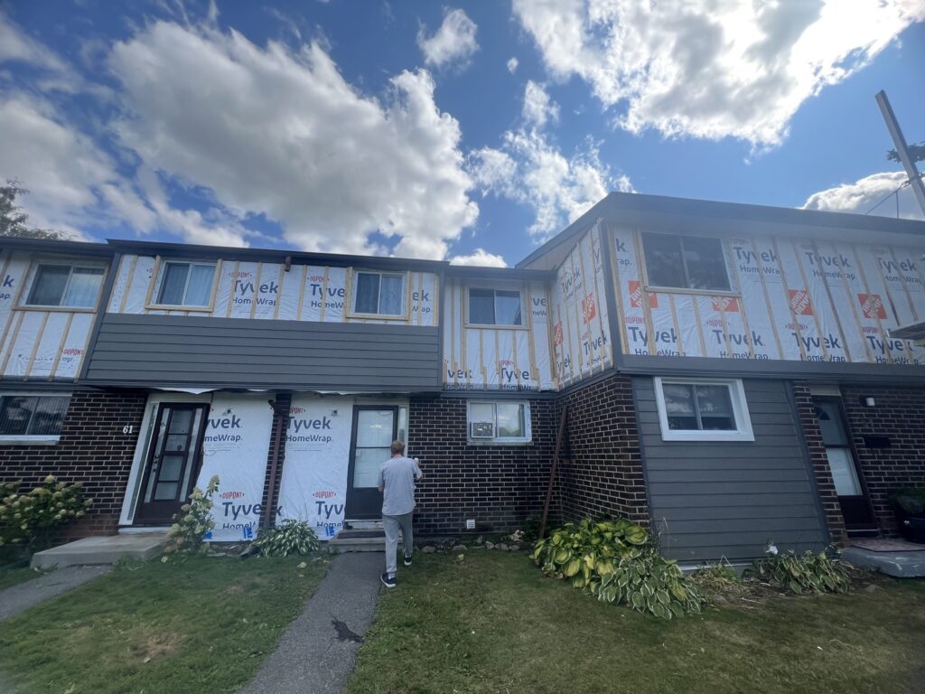 House wrap going up before new LP SmartSide siding on a townhouse block