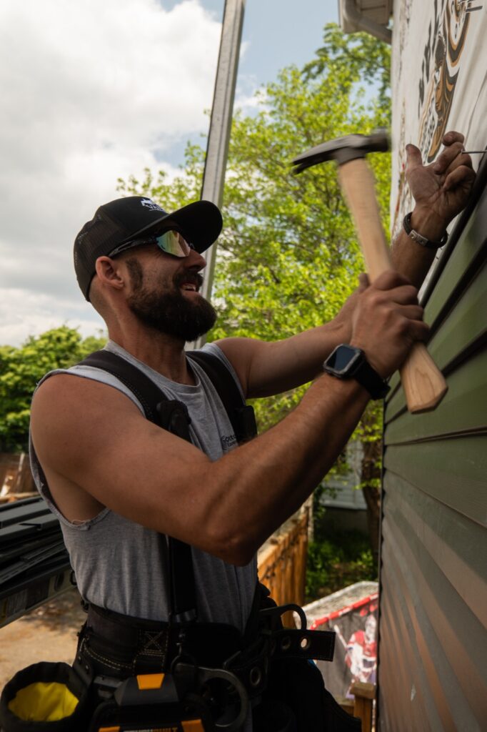 Installer nailing up new vinyl siding